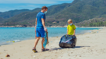 Volunteer blue face mask lazur sea sand beach. Son helps father hold black bag for pick up garbage....