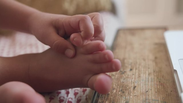 Close up shot of cute fingers, feet, and toes of a five year old child in slow motion
