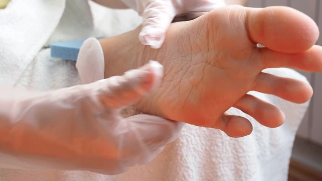 Woman gives herself a foot massage. female rubs the sole of her foot to improve blood circulation.