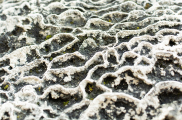 Abstract waveform texture weathered stone surface. Stone surface with traces of erosion. Gray Black White. Macro close-up