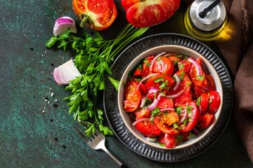 Summer Vegetable salad with fresh tomato, onion and olive oil. Healthy food. Top view flat lay. Copy space.