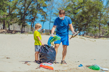 Volunteer blue face mask forest sand beach. Son helps father hold black bag for pick up garbage....