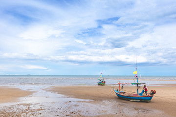 Naklejka na ściany i meble Seascape in Thailand with fishing boats on low tide beach and blue sky.
