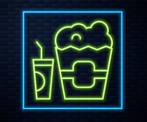 Glowing neon line Popcorn in cardboard box and paper glass with drinking straw and water icon isolated on brick wall background. Soda drink glass. Vector.