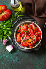 Summer Vegetable salad with fresh tomato, onion and olive oil. Healthy food. Top view flat lay. Copy space.