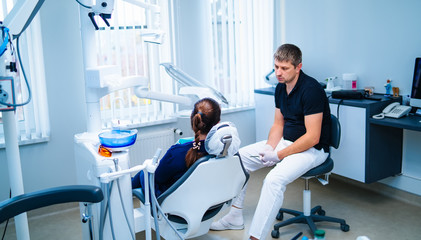 Fototapeta premium Dentist gives consultation before examining patient. Woman at consultation in dentist office.