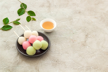 Japanese Dango dessert in pink, white and green colors, copy space