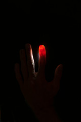 Abstract background of Illuminated and transparent red finger with visible vein on black background with copy space