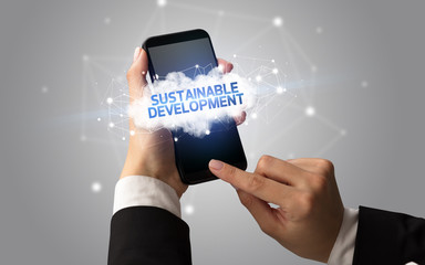 Female hand touching smartphone with SUSTAINABLE DEVELOPMENT inscription, cloud business concept