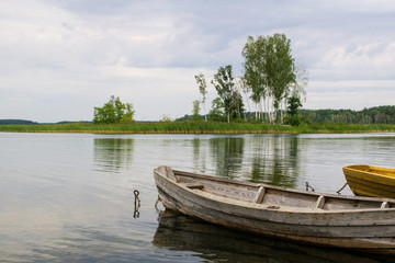 Boat on the lake. Wooden boat on a calm summer lake or river in summer. Zen nature background.
