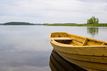 Obraz premium Boat on the lake. Wooden boat on a calm summer lake or river in summer. Zen nature background.