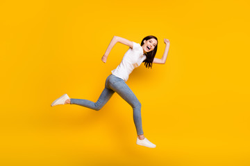 Full length body size view of her she pretty childish cheerful cheery thin girl sprinter jumping running having fun motion active life isolated bright vivid shine vibrant yellow color background