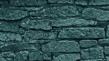 Teal blue colored stone wall texture. Rough masonry turquoise abstract background. Chipped rock dark backdrop