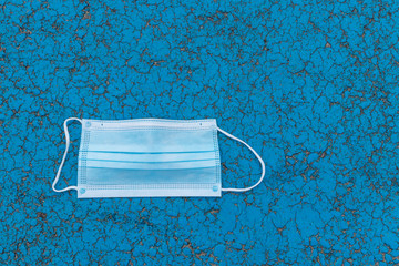 Used medical protective mask thrown on the floor.