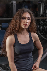 Fototapeta na wymiar a girl with an athletic physique and long hair posing for a photo in a fitness club