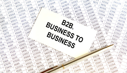 Obraz premium On the table are financial reports, a pen, a magnifying glass and a notebook with the inscription - B2B. Business to Business. Business and finance concept.
