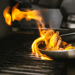Cooking shrimps with lemon in a pan on the flame