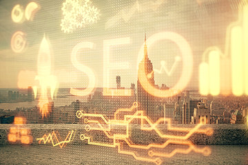 SEO hologram on city view with skyscrapers background double exposure. Search optimization concept.
