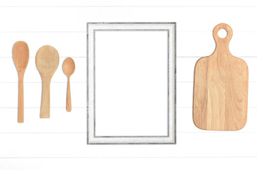 Kitchenware and empty wooden frame on white background