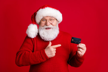 Best choice for x-mas wish dream gift buy payment. Old white grey hair beard man in santa claus headwear point finger credit card wear sweater jumper isolated bright shine color background