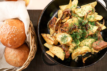 meat with potatoes and vegetables cooked in a pan and glasses with beer