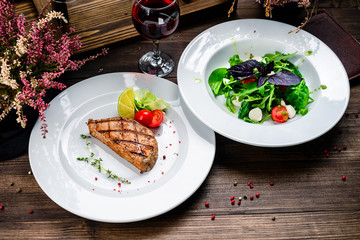 two plates of steak and salad on the table