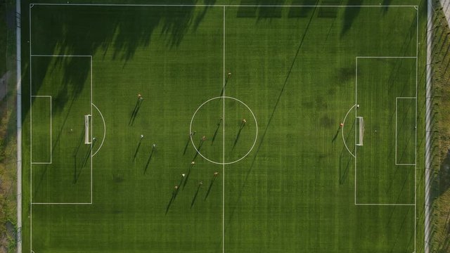 Aerial view of football club training. Big shadow on field.