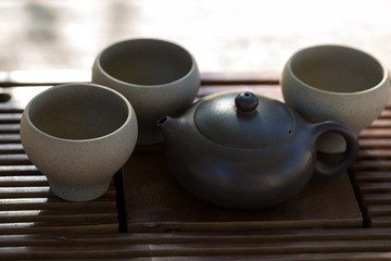 Chinese tea ceremony. Ceramic teapot made of clay and bowls on a wooden background.