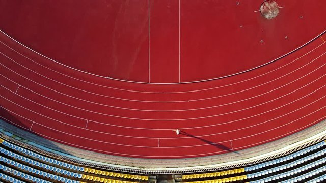 Track Runner Running On Stadium. Aerial View On Running Track