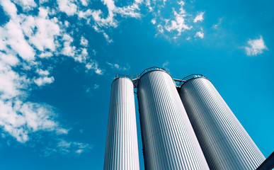 Large modern industrial tanks on blue sky background