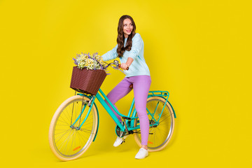 Full body size photo of stunning gorgeous student girl on retro extraordinary bike make break after long ride wear blue pullover violet pants isolated vibrant yellow color background