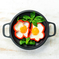 Fried scrambled eggs with sweet pepper in a pan. Top view. Free space for your text.