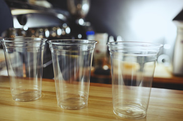 Empty disposable plastic cups for cocktail, milkshake and other beverage in cafe. Blurred image, selective focus