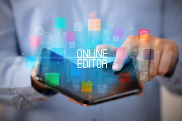 Young man holding a foldable smartphone with ONLINE EDITOR inscription, educational concept