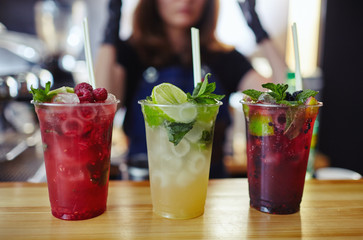 Bartender making mojito cocktail. Process of bartending in bar.Mint leaves,ice,lime - ingredients for drinks in nightclub.Blurred image, selective focus