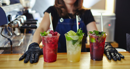 Bartender making mojito cocktail. Process of bartending in bar.Mint leaves,ice,lime - ingredients for drinks in nightclub.Blurred image, selective focus