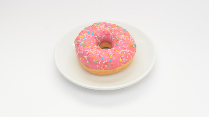 One pink glazed donut on plate on white background.Sweet dessert food for snack