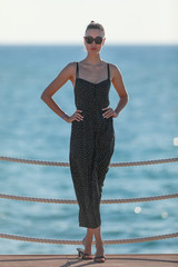 Fototapeta premium portrait of a beautiful brunette girl in a black dress on a sea background