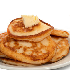 Several pancakes with a slice of butter on plate on white background. Full depth of field. With clipping path.