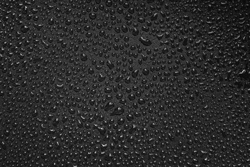 Water droplets on black background. Close-up photo of small water drops on black background.