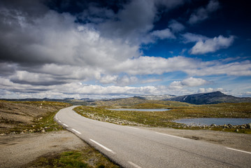Empty road. road to clouds. rocky road goes into the distance into the blue sky.  Beautiful Norway landscape, Travel in Norway