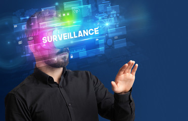 Businessman looking through Virtual Reality glasses with SURVEILLANCE inscription, innovative security concept