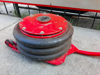 Tire. A krast-ing pneumatic jack on the ground. Close-up