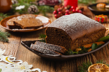 Homemade gingerbread cake. Christmas decoration. Front view. Natural wooden background.