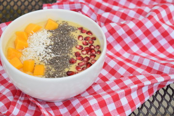 Mango smoothie bowl with coconut , pomegranate and chia seeds