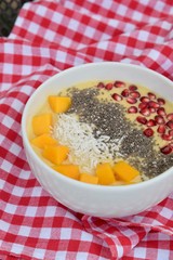 Mango smoothie bowl with coconut , pomegranate and chia seeds