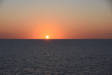 Obraz premium Sunset in Atlantic ocean. The sky is displayed in varies harmonic shades of red, orange and yellow during calm weather in spring time.