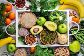 Vegetables, fruits and chives in a white tray, top view. Vegan food concept.