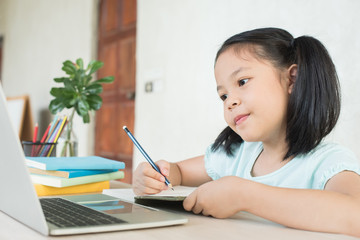 pretty  stylish schoolgirl studying homework during online lesson at home, social distance during quarantine, self-isolation, online education concept, home school, study online video call teacher.