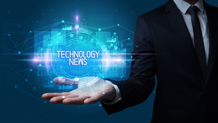 Man hand holding TECHNOLOGY NEWS inscription, technology concept